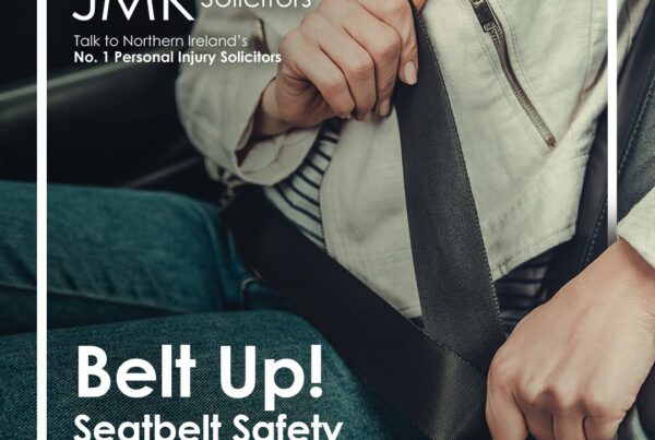 JMK Belt Up graphic. Two people putting on their seat belts in the car